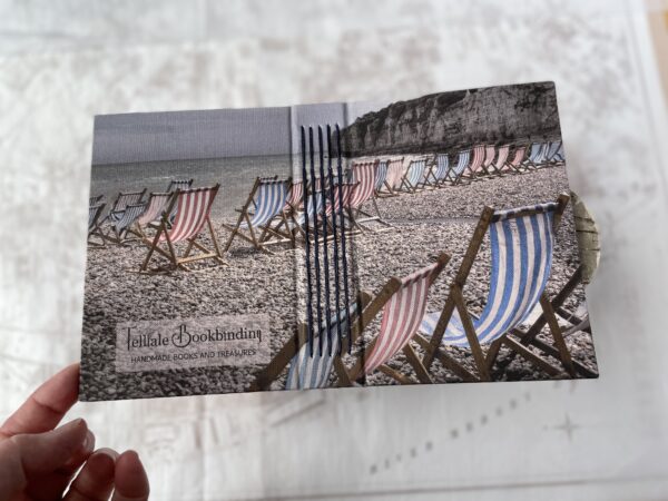 Both front and back of handmade book showing photo of striped blue and red deckchairs