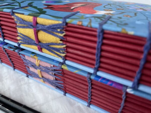 close up of spine of Coptic sketchbook with red fox folk art style